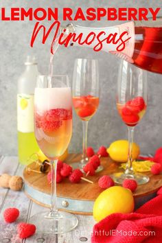 lemon raspberry mimosas are served in wine glasses and garnished with fresh raspberries