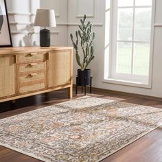 a large area rug is on the floor in front of a wooden cabinet and window