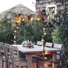 an outdoor table with chairs and lights on it