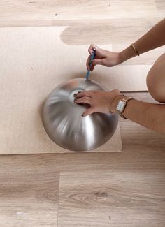 a person is using a toothbrush to brush their teeth on a metal object in the floor