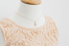 a dress on a mannequin with a gold necklace