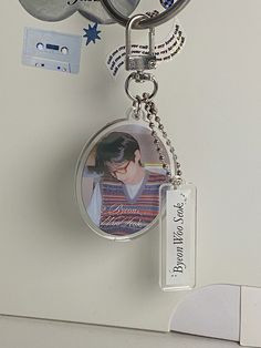 a keychain with a photo attached to it hanging from a hook on a wall