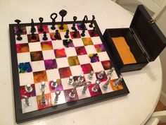 a checker board with several pieces of art on it and an open case for them