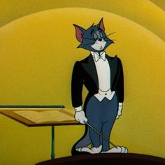 an animated cat in a tuxedo standing next to a music stand and keyboard