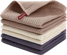 four folded towels stacked on top of each other in various colors and patterns, with the label