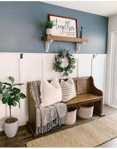 a wooden bench sitting in the middle of a living room next to a potted plant