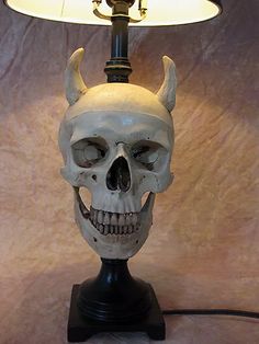 a skull lamp with horns on it and a white light in the corner behind it