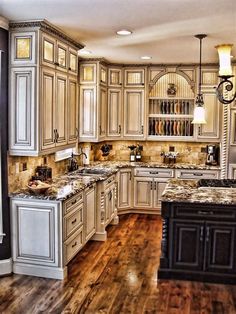 a large kitchen with wooden floors and white cabinets