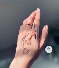 a woman's hand with a flower tattoo on it