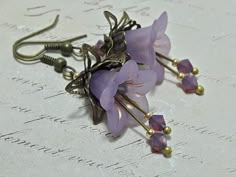 LILAC HIPPIE FLOWER EARRINGS  ▪️▪️▪️▪️▪️▪️▪️️▪️▪️▪️▪️▪️▪️ These pretty lilac purple vintage inspired floral earrings are made with super cute Lucite fairy flowers. They have matching coloured Swarovski crystals in cyclamen opal added for sparkle when they move. They are finished with antique bronze fish hook ear wires and ornate bead caps. They are very light weight and are perfect for special occasions, festivals and bridesmaids yet cute enough for everyday wear.  💜MATERIALS *Lucite Flowers  * Lilac Earrings, Fairy Earrings, Vintage Inspired Earrings, Hippie Flowers, Bronze Earrings, Hippie Earrings, Purple Earrings, Lilac Flowers, Earrings Flower