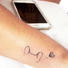 a person with a small tattoo on their arm next to a cell phone and tablet