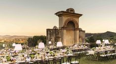 an outdoor dining area with tables and chairs set up in front of a clock tower