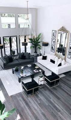 a living room filled with black and white furniture next to a large mirror on the wall