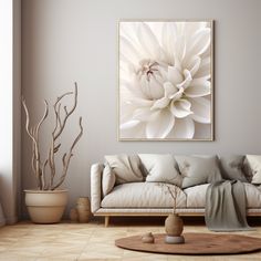 a living room with a couch, coffee table and large white flower on the wall