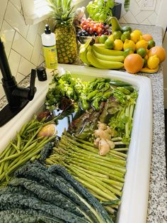 fruits and vegetables are lined up on the kitchen counter top, ready to be washed