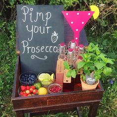 a wooden table topped with fruit and drinks next to a chalkboard sign that says,'find your proscicaa '