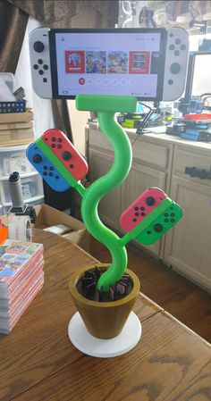 a cell phone holder that is shaped like a plant with video game controllers on it