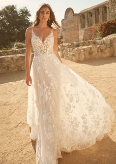 a woman in a wedding dress standing on the beach