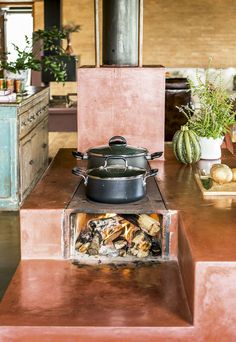 an old stove with pots and pans on it in the middle of a room