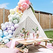 a teepee tent is set up with balloons and other decorations for a party or baby shower