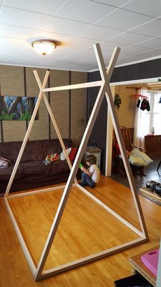 a man sitting on top of a wooden floor next to a living room filled with furniture