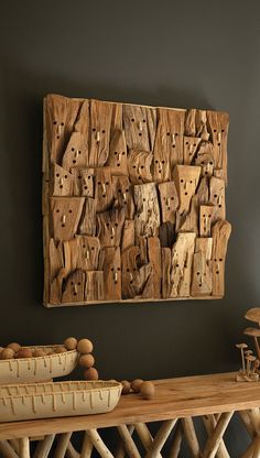 a wooden wall hanging on the side of a wall next to a table and bowls