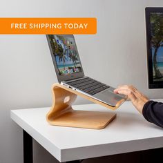 a person using a laptop on a wooden stand