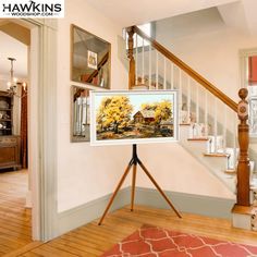 a painting is displayed on a tripod in front of the stairs and staircases