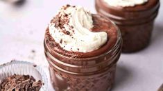 two jars filled with chocolate pudding and whipped cream