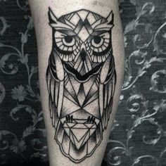 an owl tattoo on the leg with geometric shapes in black and grey colors is shown