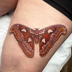 a butterfly tattoo is shown on the thigh