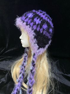 a mannequin head wearing a purple and black knitted hat with braids