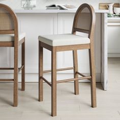 two wooden stools sitting next to each other in front of a white counter top