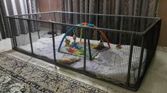 a child's playpen in the corner of a room with curtains and rugs