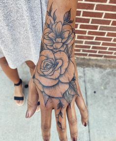 a woman's hand with a flower tattoo on it