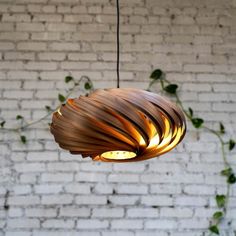 a wooden light fixture hanging from a brick wall