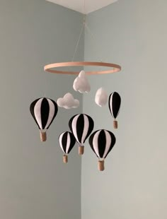 a black and white mobile with hot air balloons hanging from it's side in a room