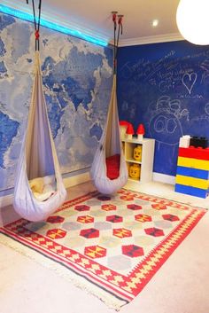 a child's bedroom with two hammocks hanging from the ceiling and a map on the wall