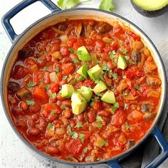 a pot filled with beans and avocado on top of a table