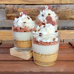 three desserts with whipped cream and chocolate chips in glass cups on a wooden table