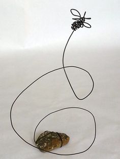 a wire sculpture with a rock on it