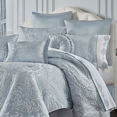 the comforter is made up with blue and white bedding, along with matching pillows