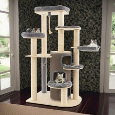 a cat tree with several cats on it in a room that has a wallpapered background