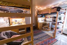 bunk beds in a dorm room with lights strung from the ceiling and rugs on the floor