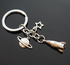 a metal keychain with an object hanging from it's side on a black surface