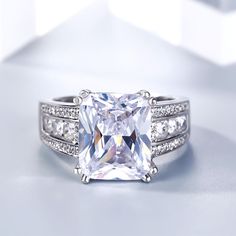 an engagement ring with a princess cut diamond and pave set diamonds on the sides