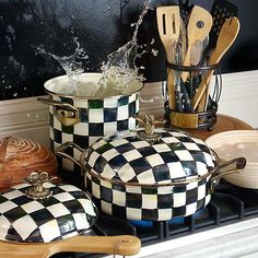 some pots and pans are sitting on the stove with cooking utensils in them