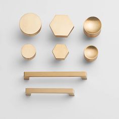 brass knobs, plates and pulls on a white surface with the handles off to the side