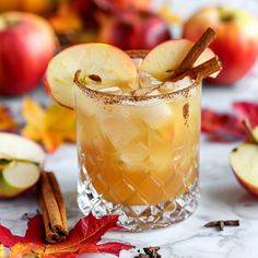 an apple cider is garnished with cinnamon and apples on the marble table