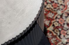 a close up of a black table with a white cloth on it and a rug in the background